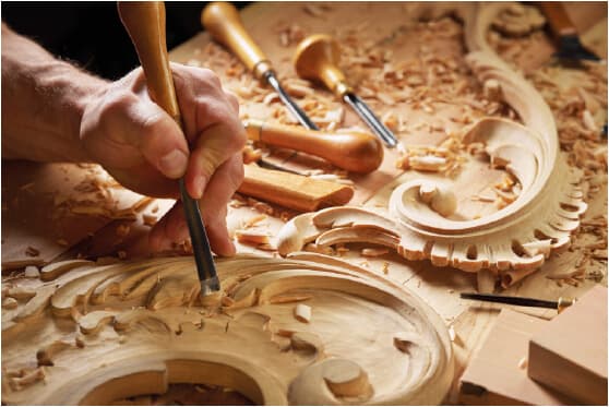 Artigiana sorridente mostra un manufatto in ceramica davanti al suo laboratorio